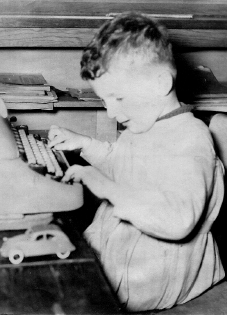Enfance de l'écriture : une grosse Remington bien avant tout site web, blouse d'écolier des années 50-60, et déjà l'automobile en vue de futurs déplacements, puisque c'est d'aller et venir qu'il s'agit...